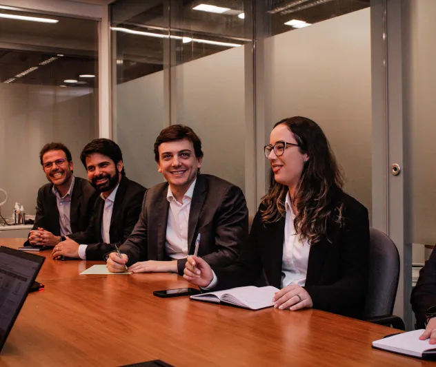 Grupo de executivos sorrindo e conversando em um ambiente corporativo