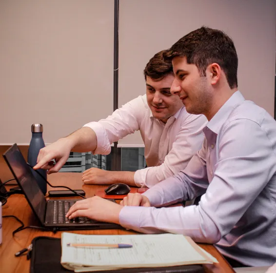 Jovens profissionais apontando para computador em escritório