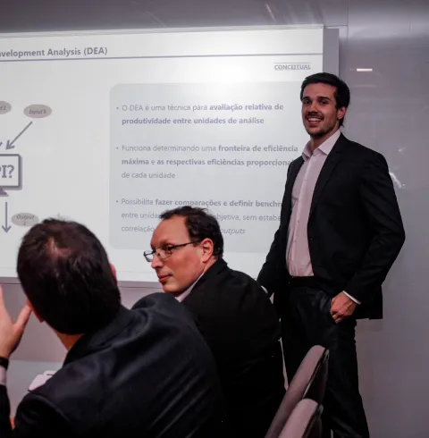 Homem apresentando um power point em uma reunião